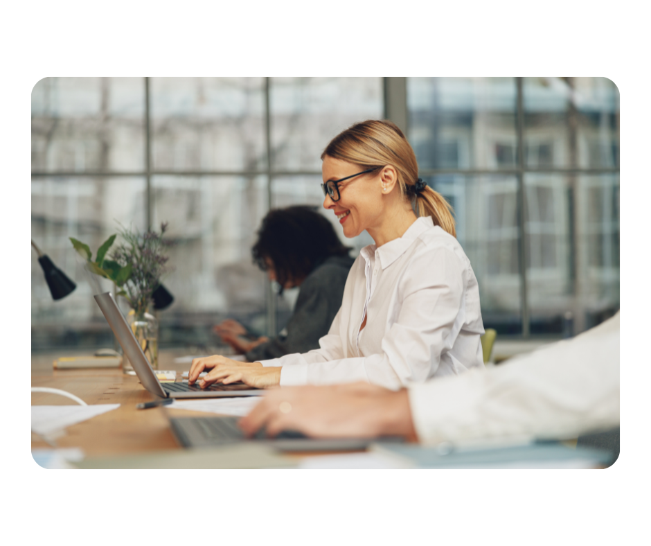 Blonde woman with glasses working in an office from profile view