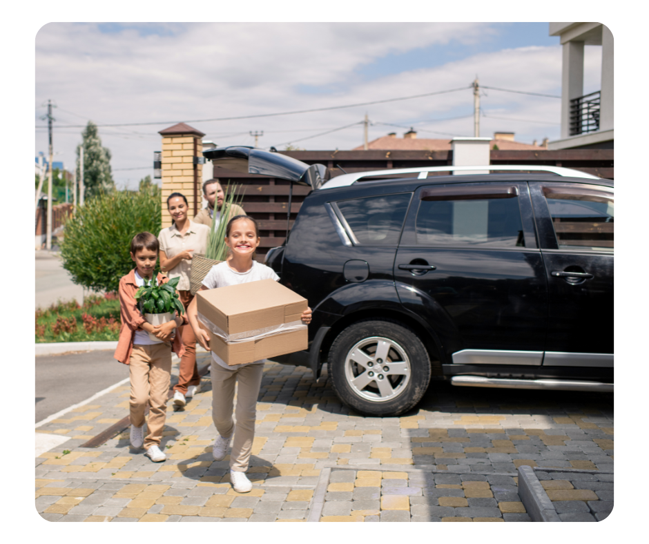 Happy family on a moving day with boxes in front of a car